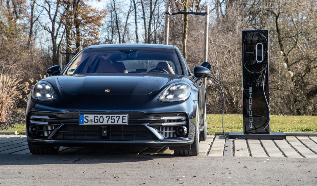 Черный автомобиль Porsche Panamera Turbo S E-Hybrid Sport Turismo 2021 года на заправке