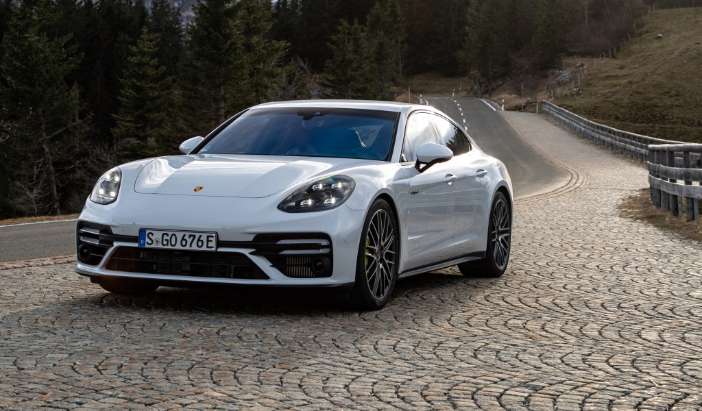 Белый автомобиль Porsche Panamera Turbo S E-Hybrid 2021 года на дороге