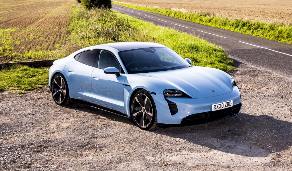Быстрый автомобиль Porsche Taycan 4S 2021 года на фоне поля