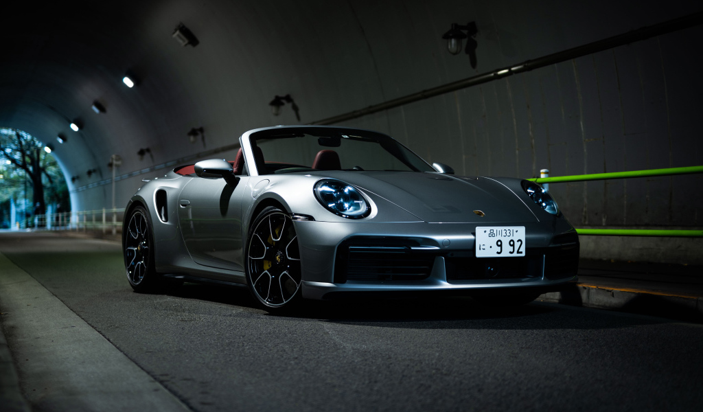 Серебристый Porsche 911 Turbo S Cabriolet 2021 года в тоннеле