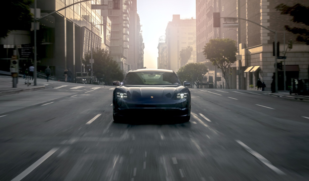 Черный стильный автомобиль  Porsche Taycan Turbo, 2020 года на дороге в городе