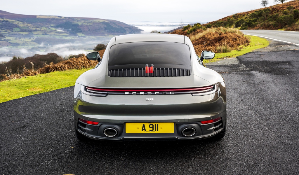 Автомобиль Porsche 911 Carrera на дороге у обрыва