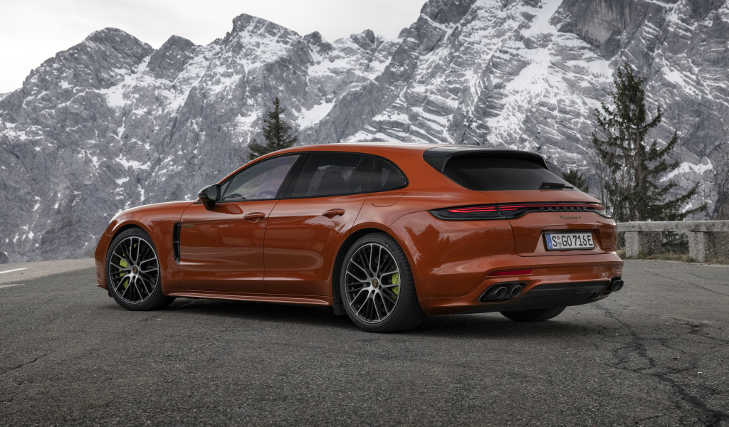 Красный автомобиль Porsche Panamera 4 E-Hybrid 2021 года на фоне гор