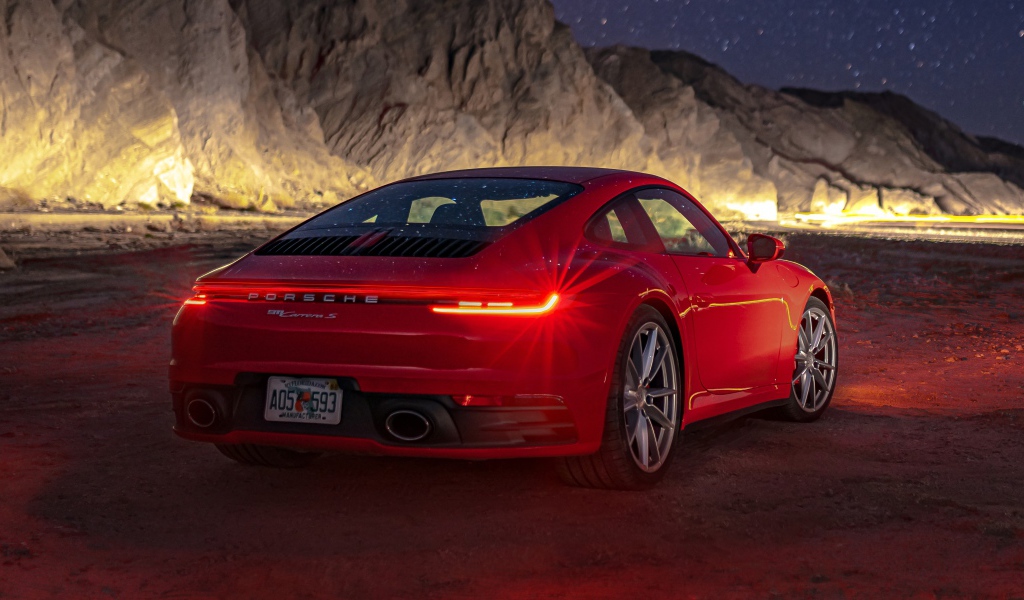 Красный автомобиль  Porsche 911 Carrera S, 2020 года в горах ночью 
