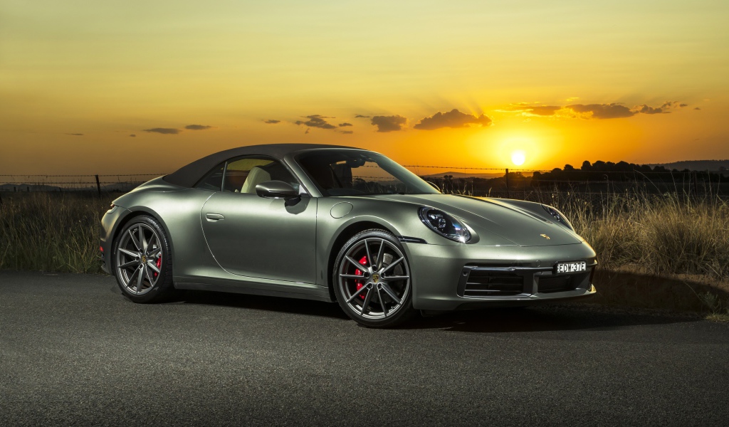 Серебристый Porsche 911 Carrera S Cabriolet 2020 года на закате 
