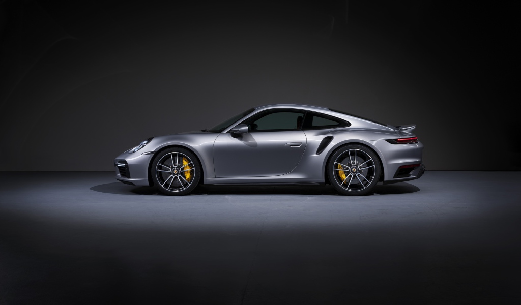 Серебристый автомобиль Porsche 911 Turbo S 2020 года вид сбоку 