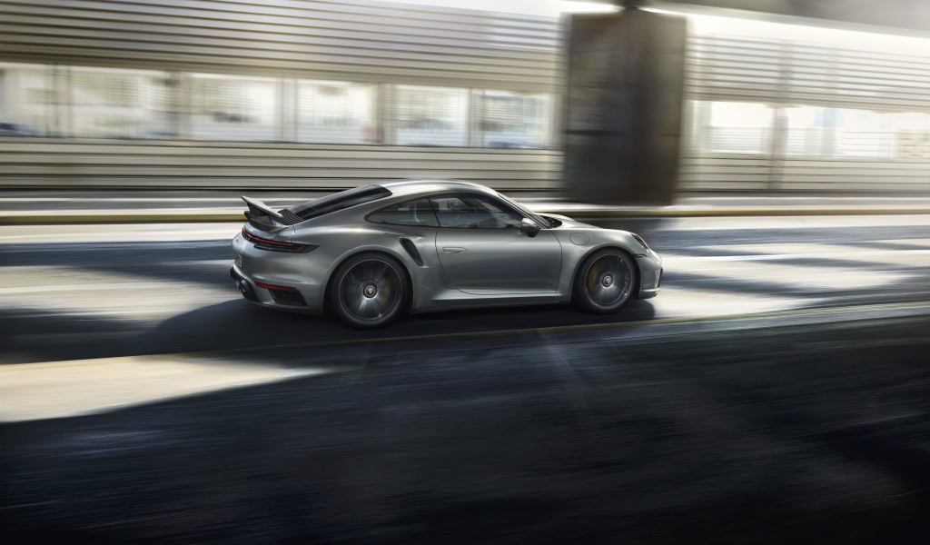 Серебристый автомобиль Porsche 911 Turbo S 2020 года на трассе 