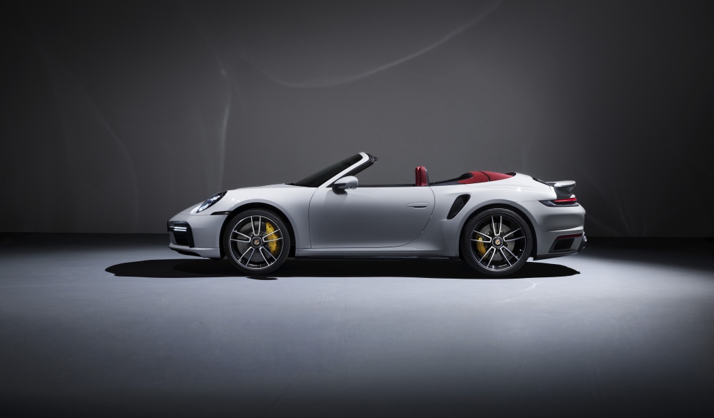 Белый автомобиль Porsche 911 Turbo S Cabriolet 2020 года на сером фоне