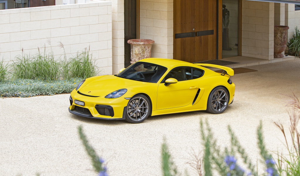 Желтый автомобиль Porsche 718 Cayman GT4,  2020 года