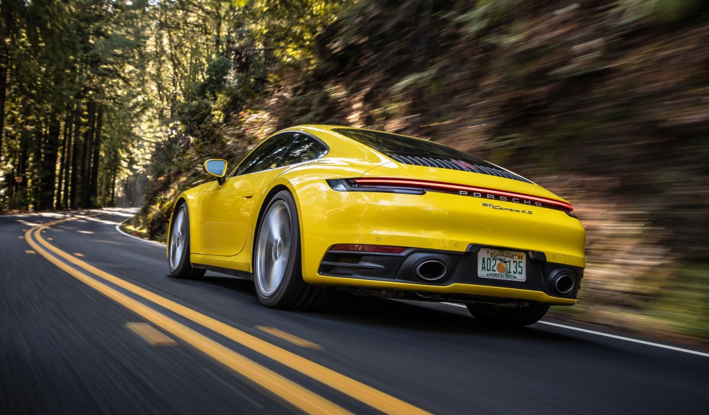 Желтый автомобиль  Porsche 911 Carrera 4S, 2020 года на трассе 