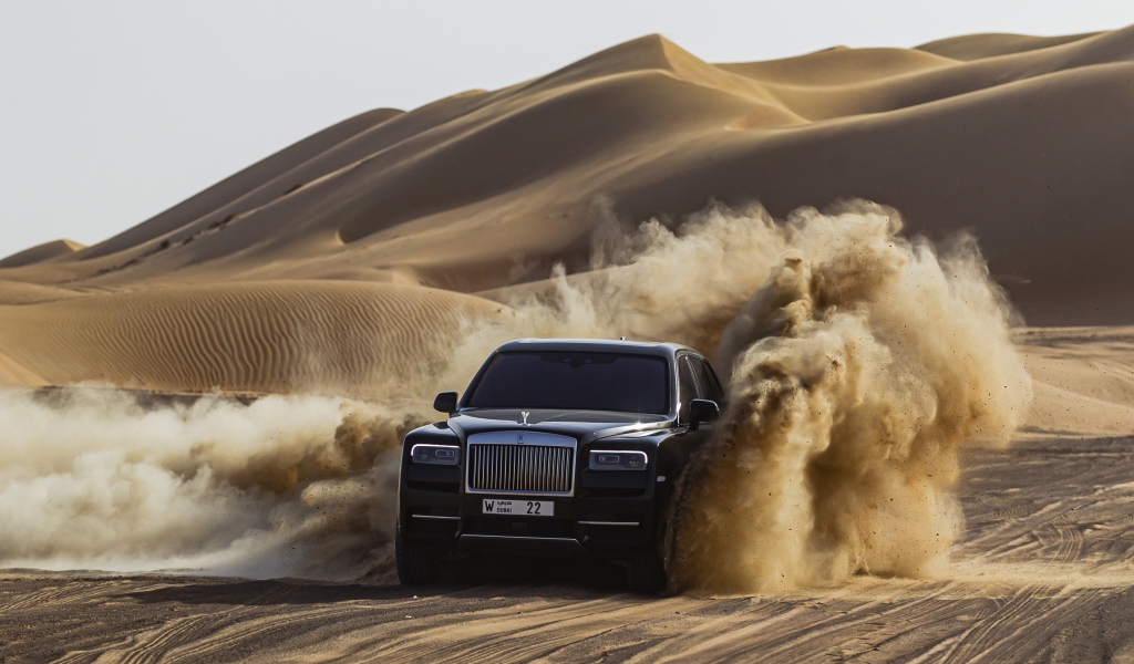 Черный автомобиль Rolls-Royce Cullinan в пустыне