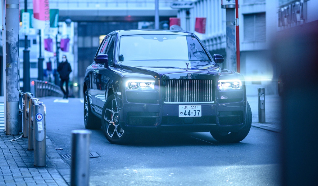 Автомобиль Rolls-Royce Cullinan с включенными фарами