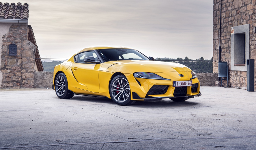 Желтый автомобиль Toyota GR Supra 2 2020 года у здания 