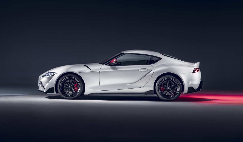 Серый автомобиль Toyota GR Supra 2L 2020 года вид сбоку на сером фоне