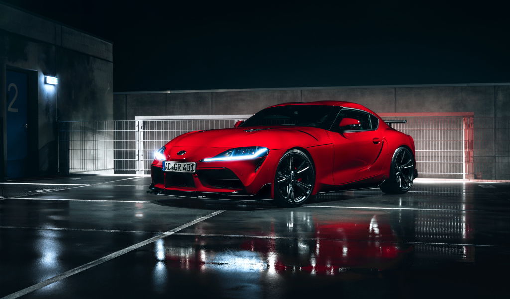 Красный автомобиль Toyota GR Supra AC Schnitzer 2019 года у гаража