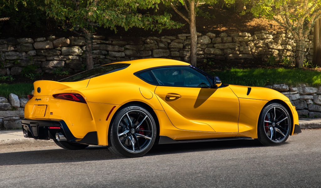Желтый автомобиль Toyota GR Supra 2, 2021 года вид сбоку 
