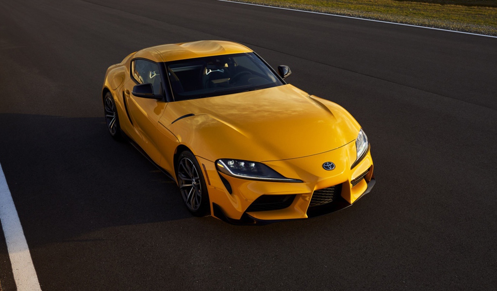 Желтый автомобиль  Toyota GR Supra, 2021 года на трассе 