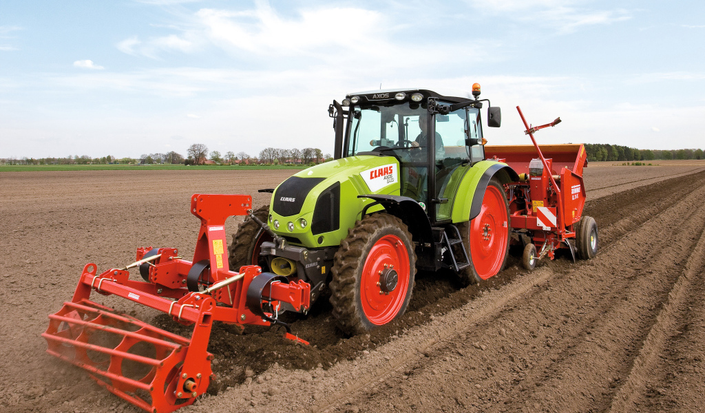 Большой комбайн сеет в поле 