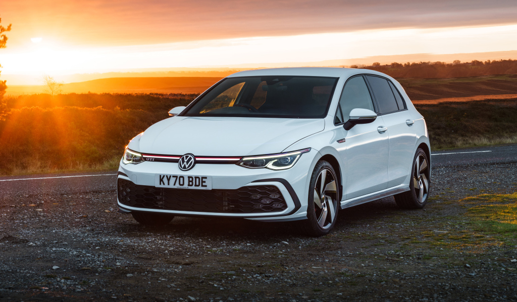 Белый автомобиль Volkswagen Golf GTI 2020 года на закате солнца