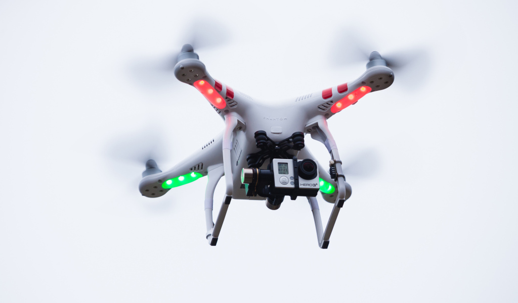 Квадрокоптер с видеокамерой на белом фоне