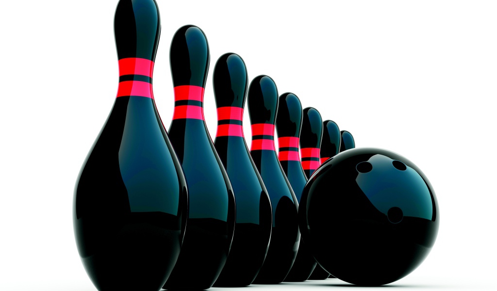 Черные кегли и шар для боулинга на белом фоне