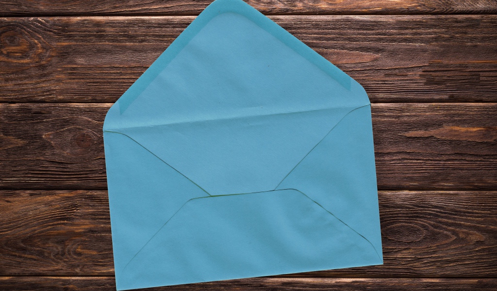 Голубой бумажный конверт на деревянном фоне