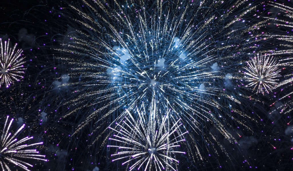 Яркие искры праздничного фейерверка  в ночном небе 