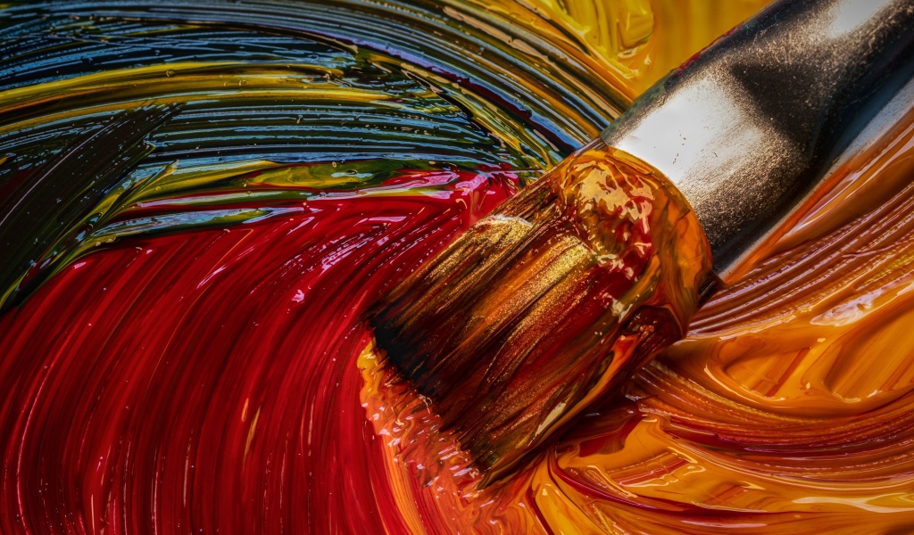 Кисть смешивает краски в палитре 