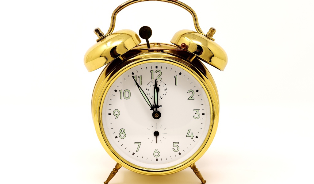 Золотой будильник на белом фоне 