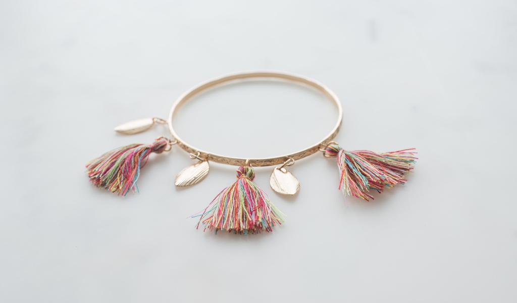 Золотой браслет на сером фоне