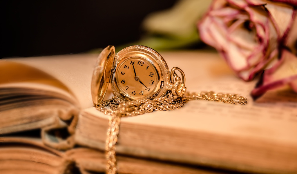 Gold women's watch on a chain lie on the book
