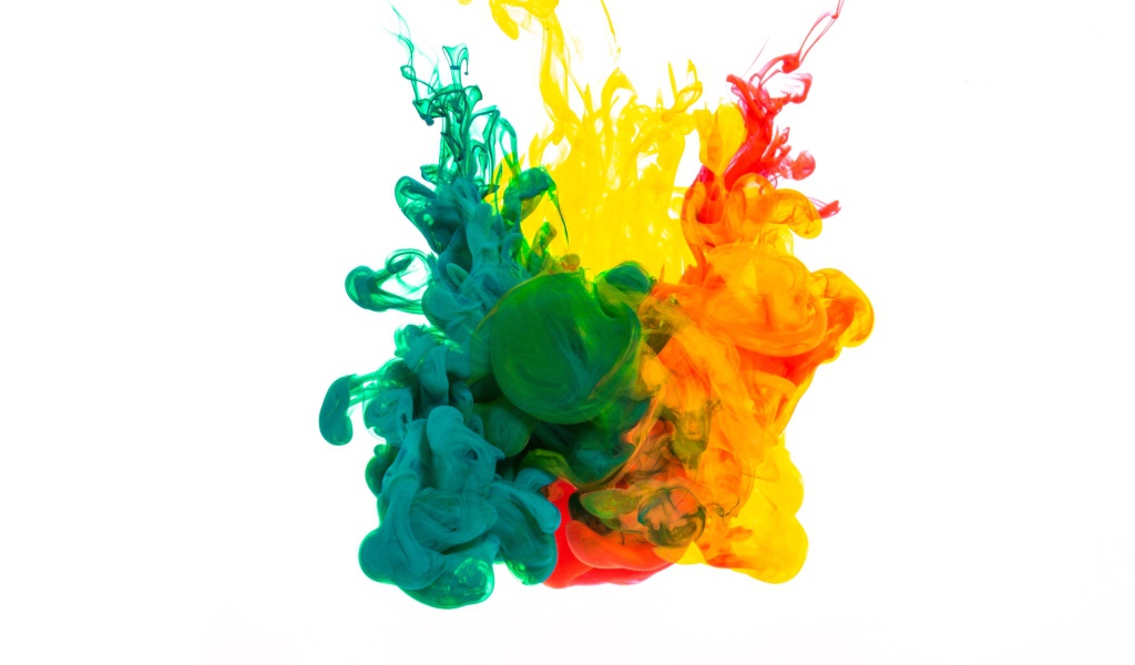 Зеленая и желтая краска растворяются в воде на белом фоне