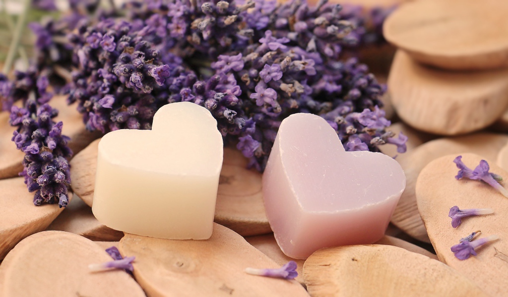 Мыло в форме сердца на столе с цветами лаванды