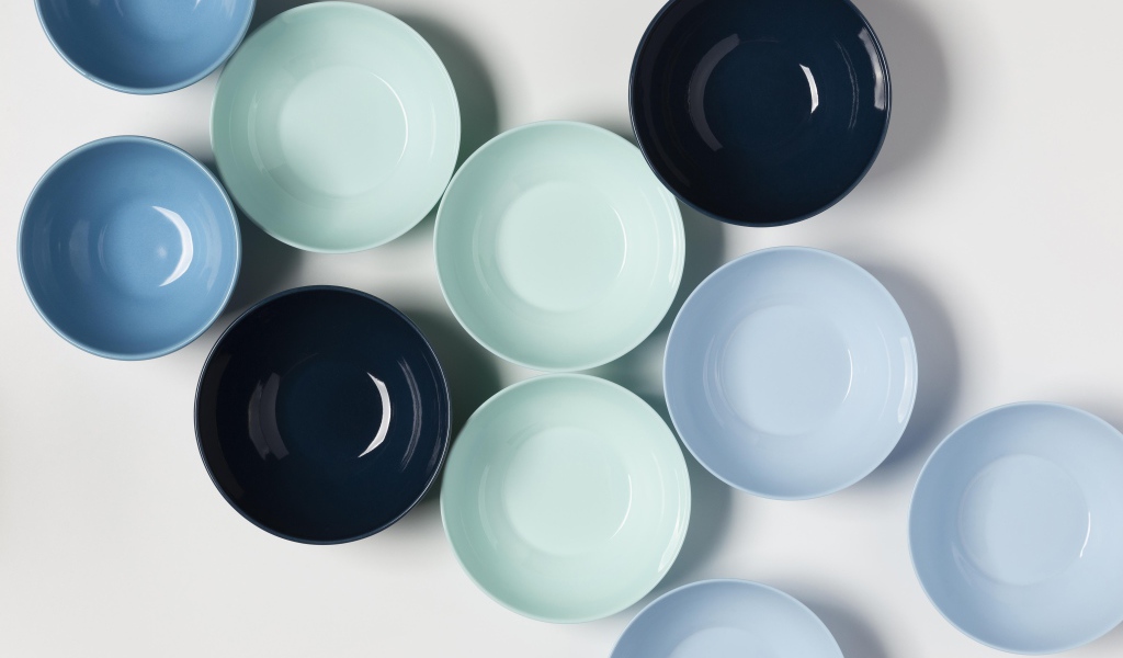 Разноцветные фарфоровые миски на столе 