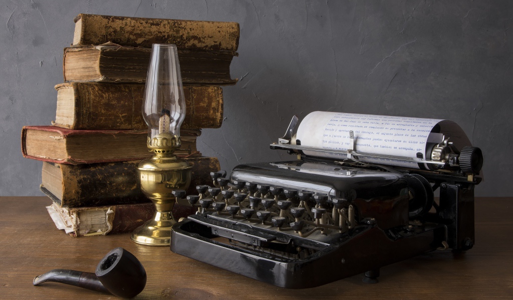 Старая печатная машинка, книги, керосиновая лампа и трубка на столе 