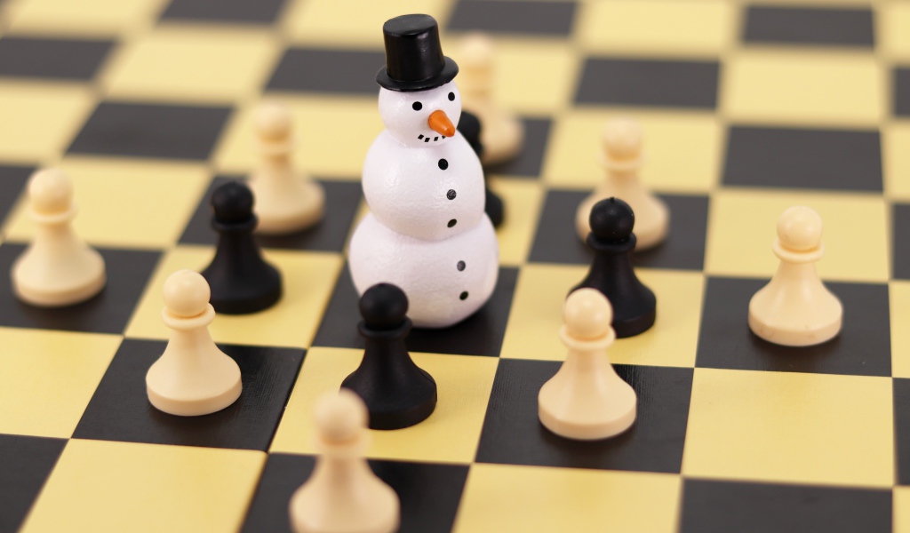 Фигурка снеговика на шахматной доске