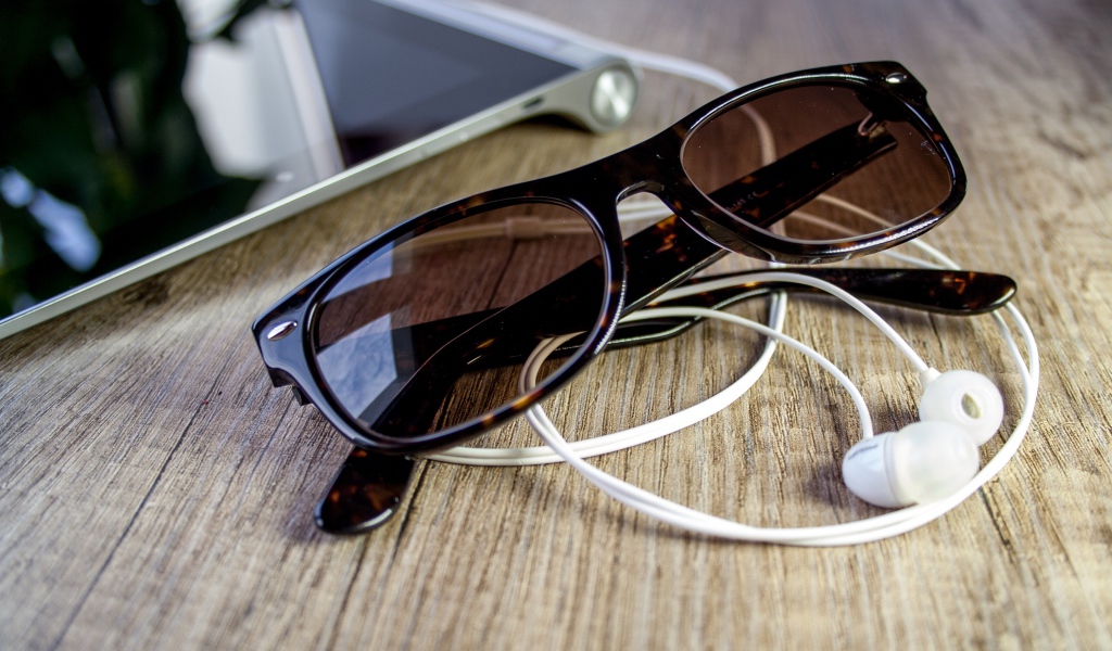 Солнечные очки с наушниками на столе