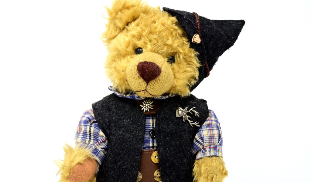 Медвежонок Тедди в костюме на белом фоне