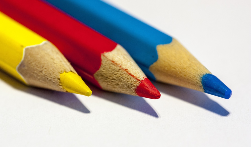 Три разноцветных карандаша на белом фоне