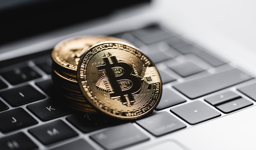 Монеты биткоин лежат на клавиатуре ноутбука 