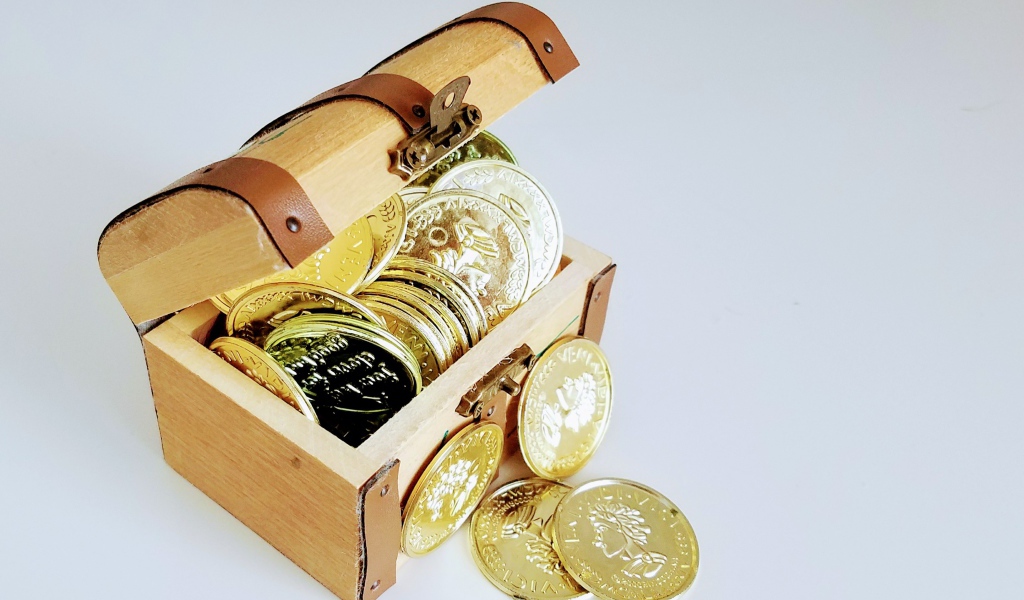 Золотые монеты в сундуке на сером фоне