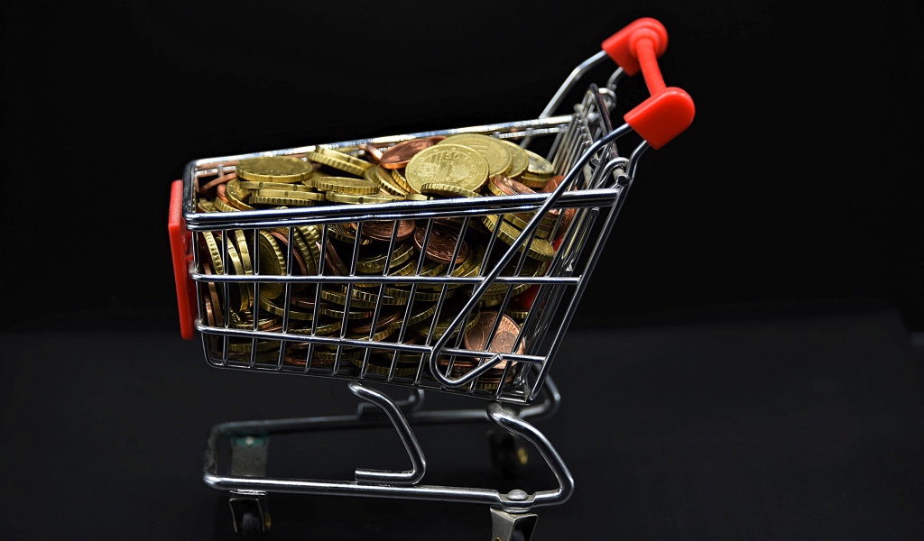 Железная тележка с монетами на черном фоне 