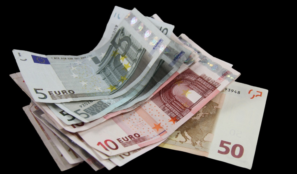 Много бумажных купюр евро на черном фоне