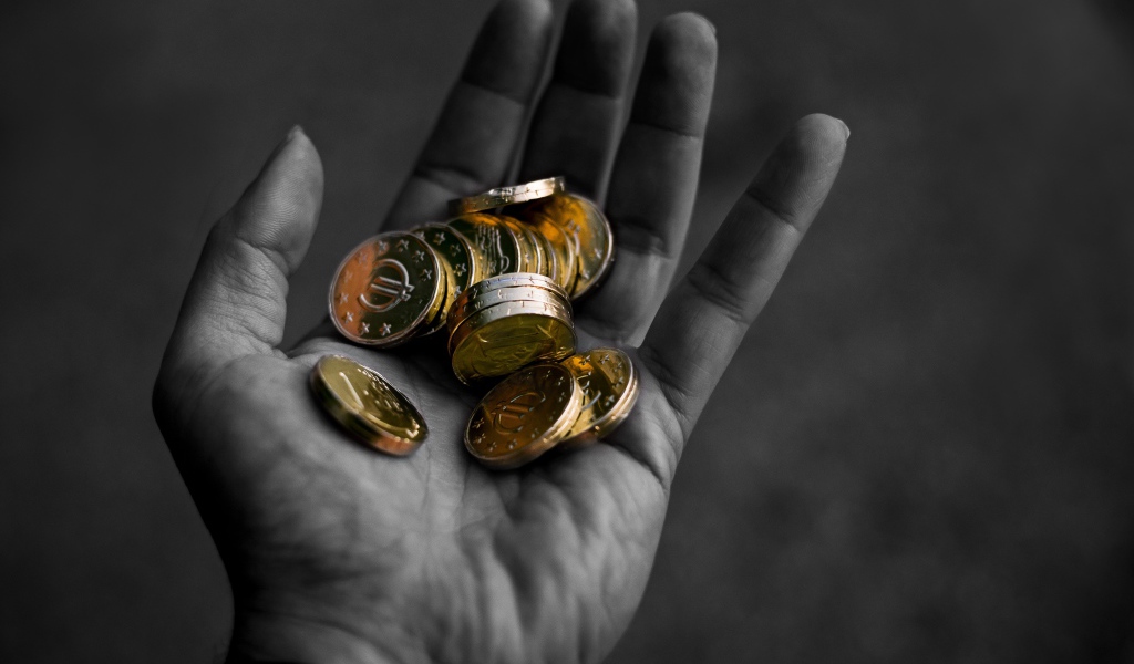 Много монет в руке у мужчины