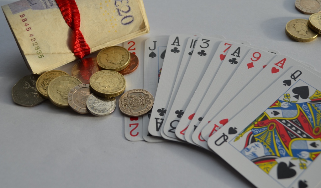 Деньги, монеты и колода карт на столе