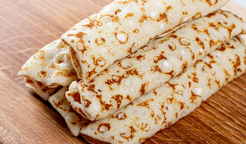 Аппетитные блины на деревянном столе 