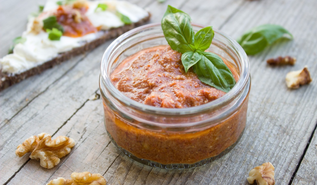 Икра в банке с базиликом на столе с орехами 