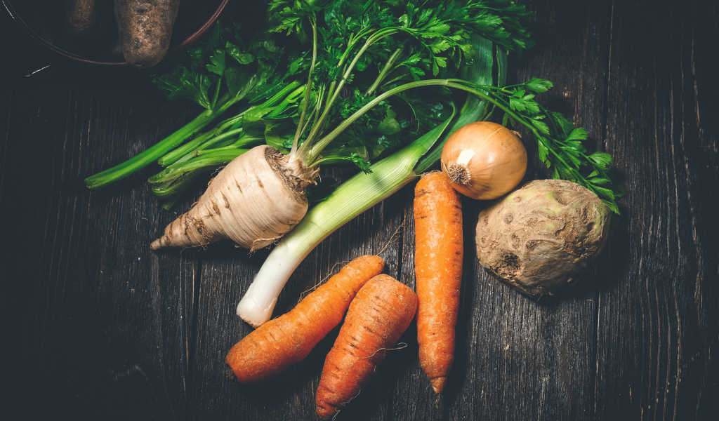 Сельдерей, морковь и лук на столе 