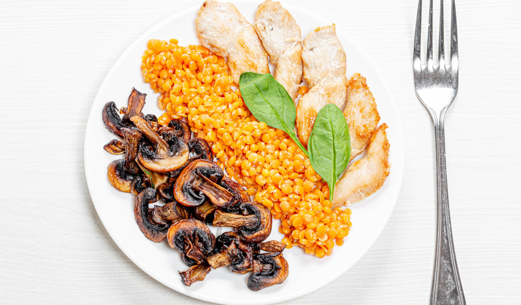 Шампиньоны на тарелке с чечевицей и курицей