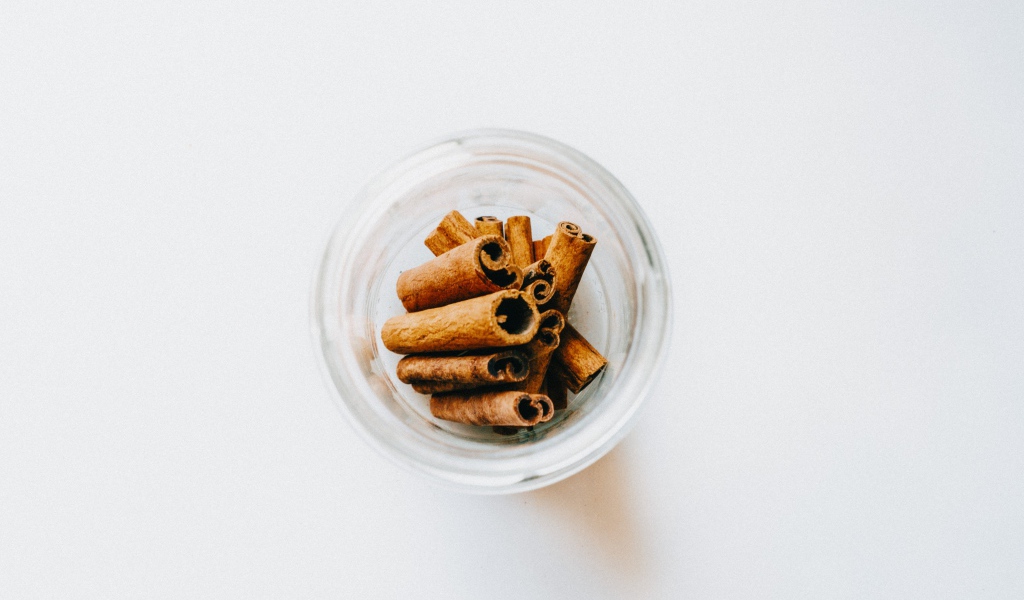 Корица в стеклянной банке на белом фоне 